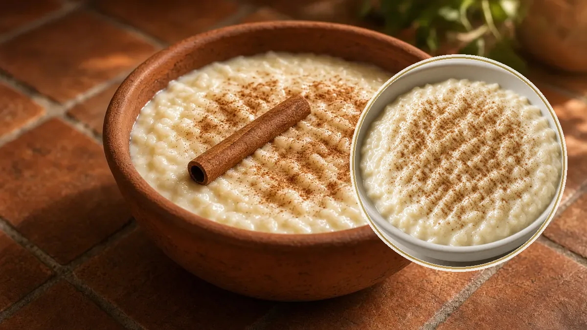 Arroz con leche cremoso en un cuenco de barro, espolvoreado con canela y una raja al lado.